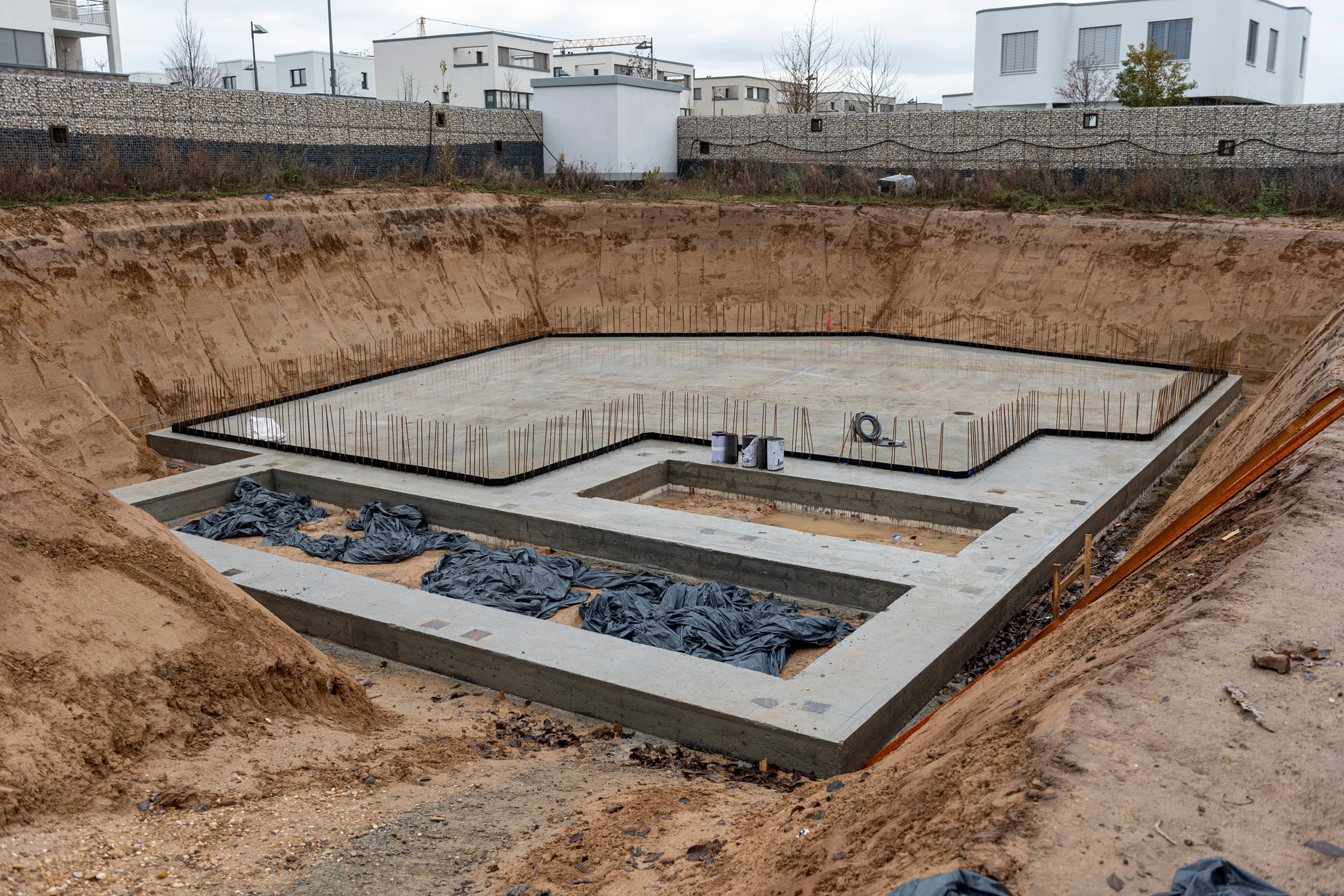 Chantier de construction extérieur montrant les fondations d'un bâtiment en cours de réalisation
