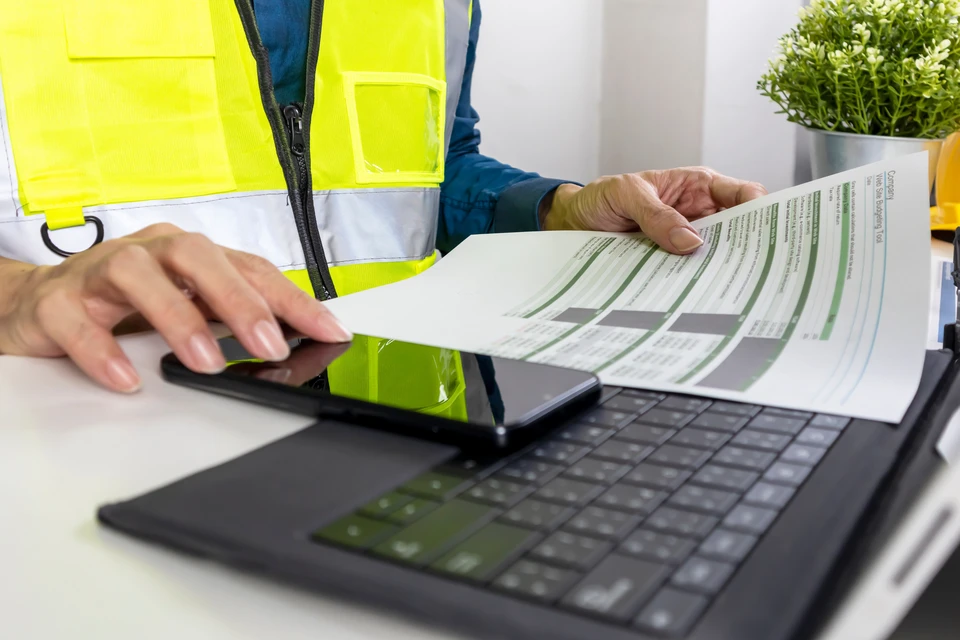 Bureau de travail avec documents contractuels, stylo professionnel, calculatrice et trousseau de clés dorées au premier plan
