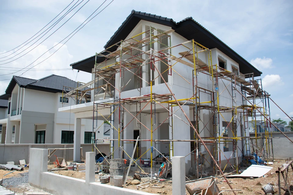 Chantier de construction résidentielle en cours, vue aérienne d'une maison en construction avec ouvriers sur le toit