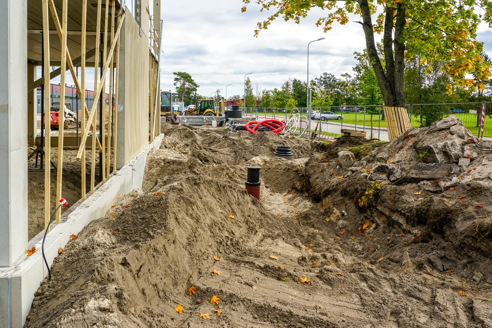 Chantier extérieur avec pelleteuse-chargeuse jaune en activité sur terrain de construction