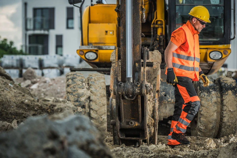 Chantier de terrassement en extérieur avec chargeuse sur pneus jaune et orange en activité