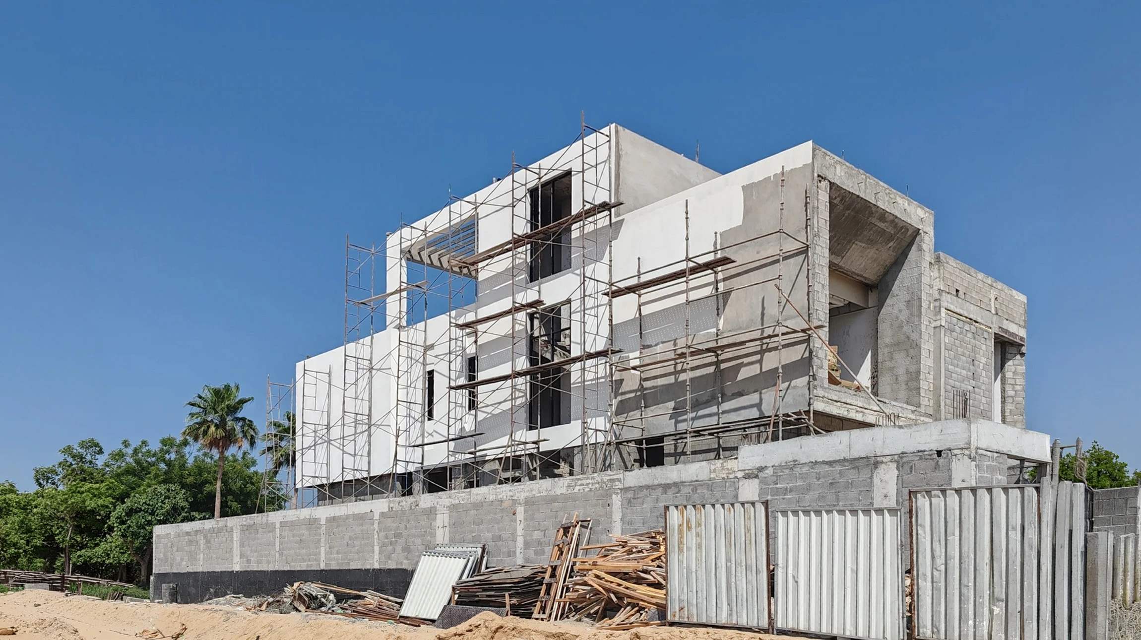 Chantier de construction résidentielle en cours, ouvriers effectuant travaux de maçonnerie et fondations